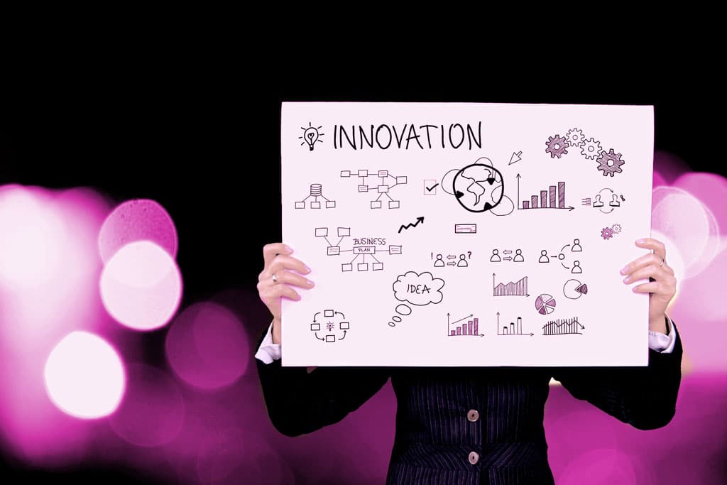 Person holding an innovation diagram featuring ideas, business planning, charts, processes and creative strategy.