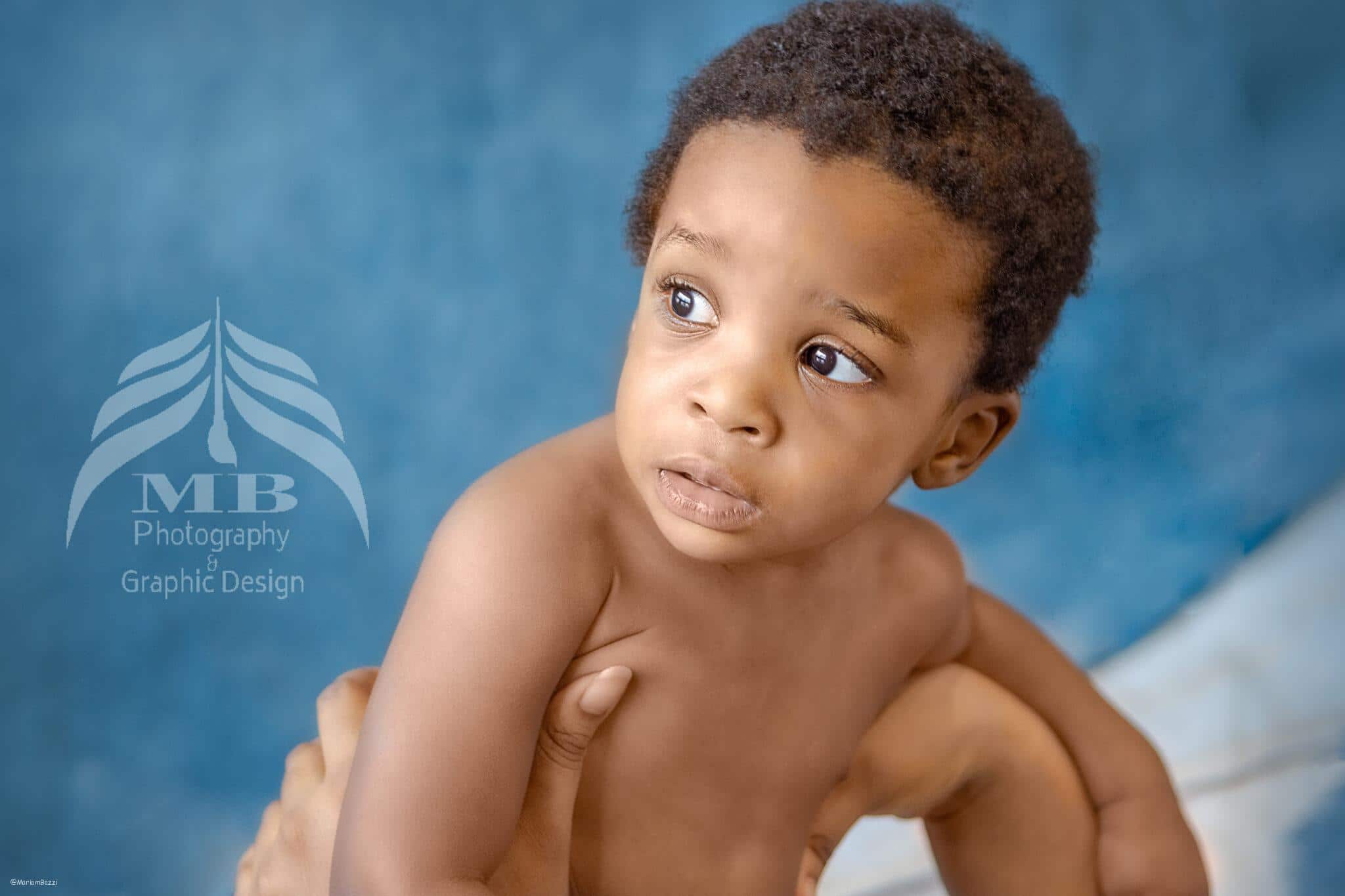 Photography Portfolio 49 Mariam Cheaitou Bazzi Photography Portfolio in Windsor Baby boy looking to the side during a simple milestone photography portrait against a soft blue studio backdrop in Windsor, Ontario.