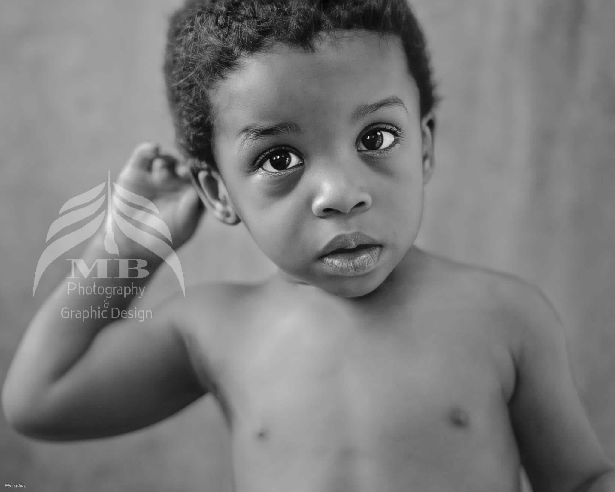Photography Portfolio 47 Mariam Cheaitou Bazzi Photography Portfolio in Windsor Black-and-white portrait of a baby boy looking toward the camera with one hand raised behind his head during a milestone photography session in Windsor, Ontario.