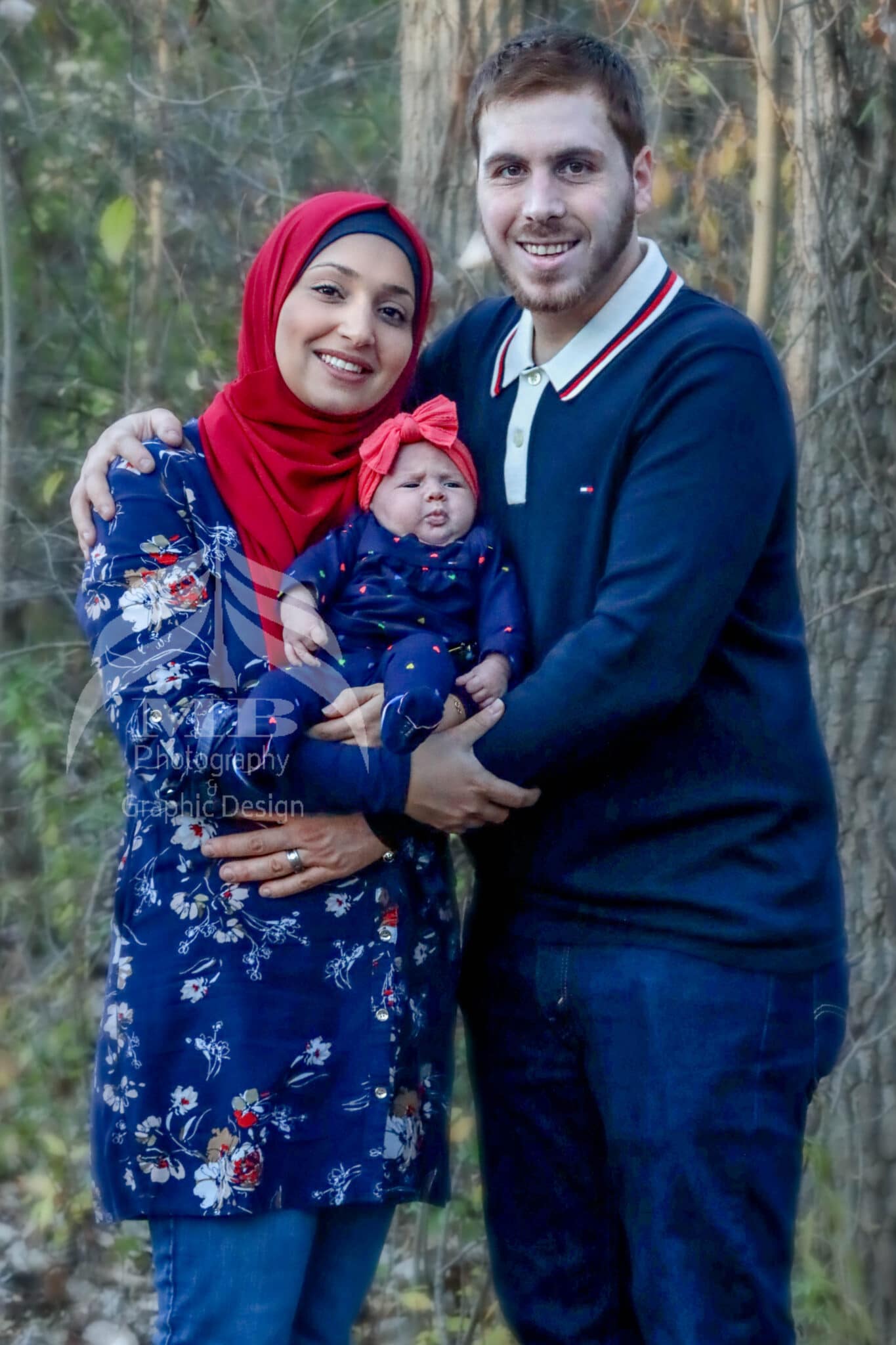 Photography Portfolio 52 Mariam Cheaitou Bazzi Photography Portfolio in Windsor Mother and father holding their baby during a relaxed outdoor family photography session surrounded by trees in Windsor, Ontario.