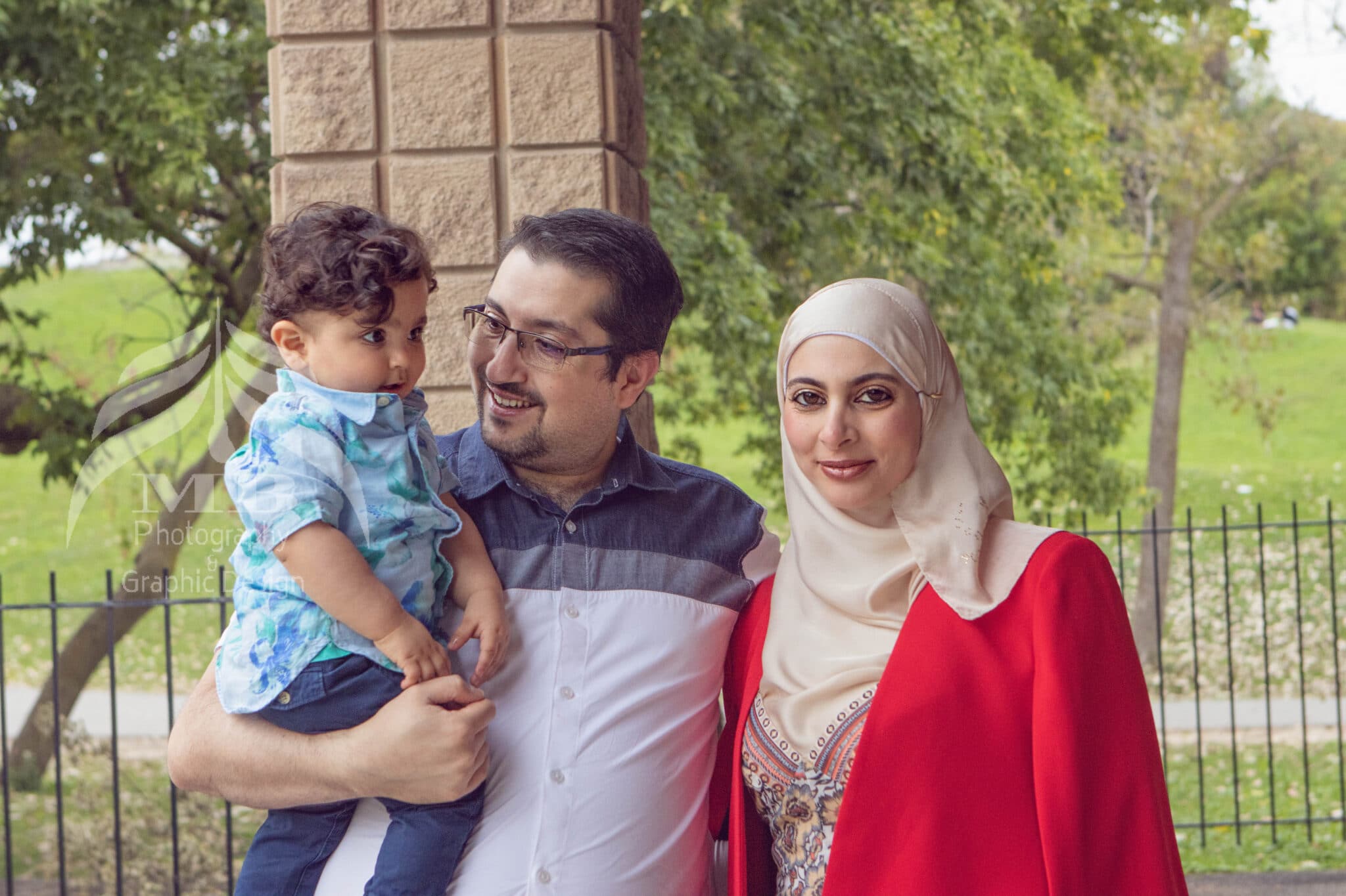 Photography Portfolio 51 Mariam Cheaitou Bazzi Photography Portfolio in Windsor Family of three smiling together outdoors in a Windsor Ontario park, on-location family photography by Windsor Ontario photographer