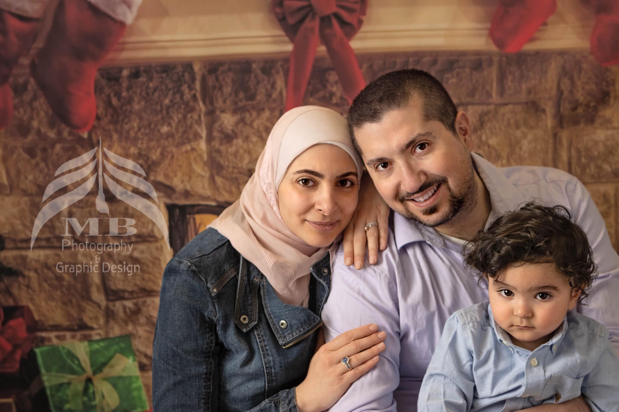 Photography Portfolio 50 Mariam Cheaitou Bazzi Photography Portfolio in Windsor Family of three posed together in front of holiday backdrop, studio family photography by Windsor Ontario photographer