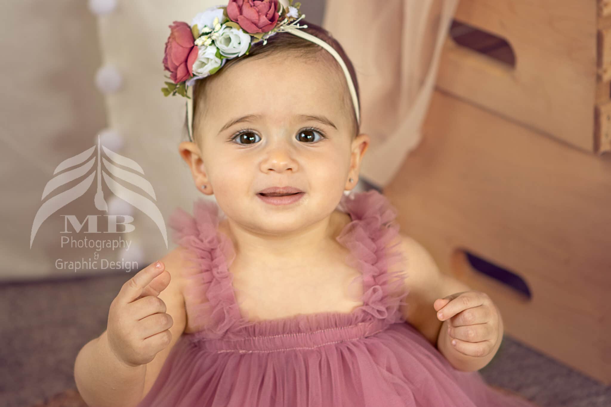 Photography Portfolio 45 Mariam Cheaitou Bazzi Photography Portfolio in Windsor Smiling one year old girl in pink tulle dress and floral crown, first birthday milestone photography by Windsor Ontario photographer