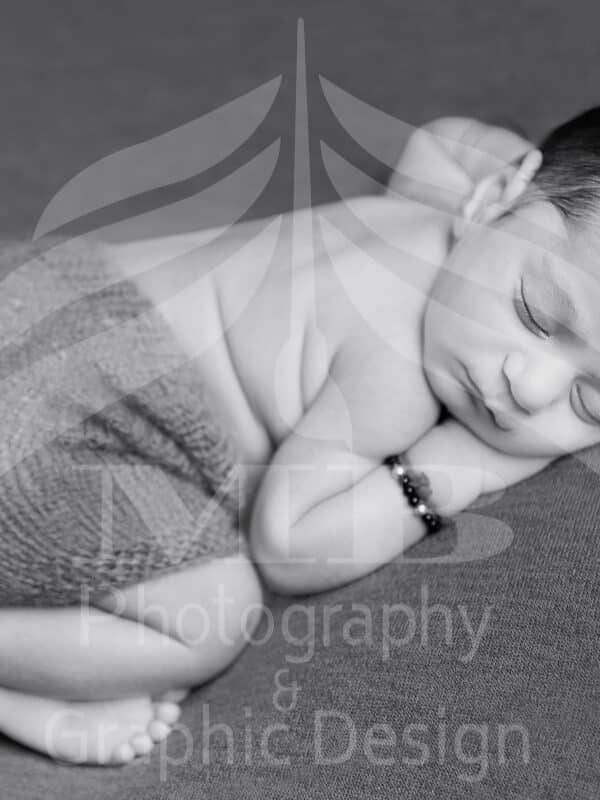 Photography Portfolio 20 Mariam Cheaitou Bazzi Photography Portfolio in Windsor Black and white Newborn baby boy sleeping in curled pose on grey wrap, professional newborn photography by Windsor Ontario photographer
